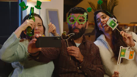 Group-Of-Friends-Dressing-Up-With-Irish-Novelties-And-Props-At-Home-Or-In-Bar-Posing-For-Selfie-Celebrating-At-St-Patrick's-Day-Party-1